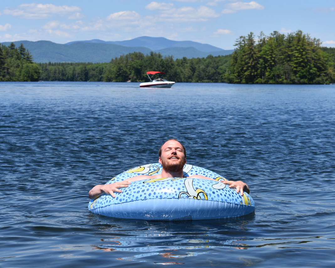 nh-lakes-membership-man-in-lake Man enjoys the sun while in an inner tube on a New Hampshire Lake