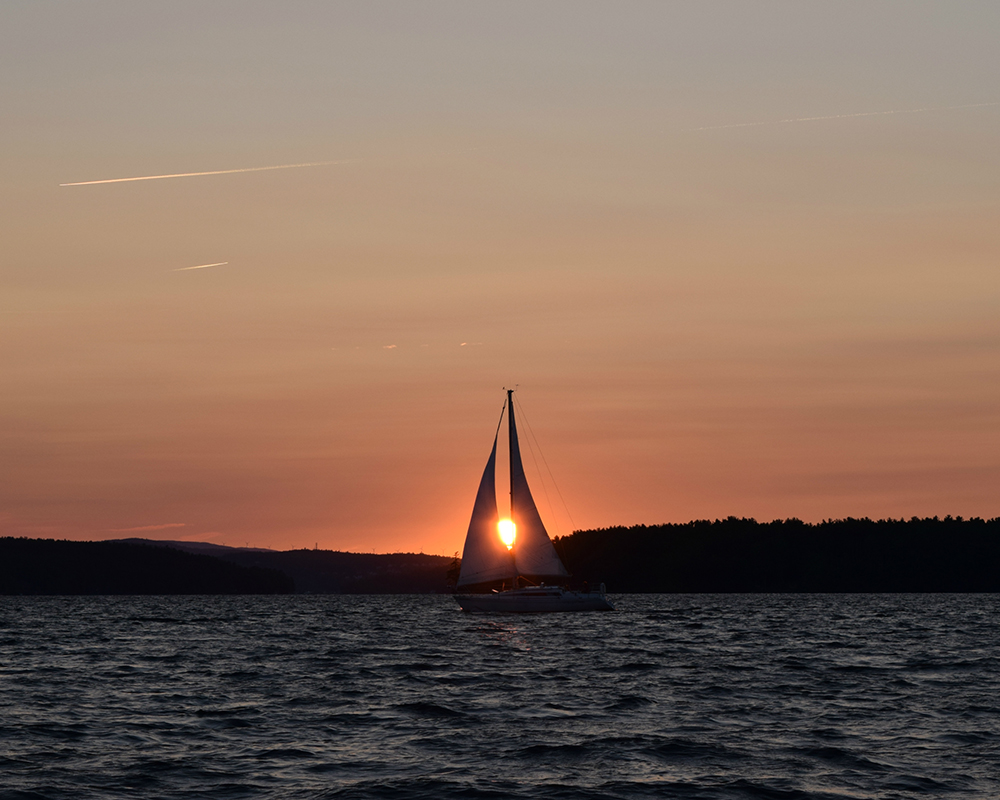 nh-lakes-sailboat-sunset A sailboat on a New Hampshire lake at sunset